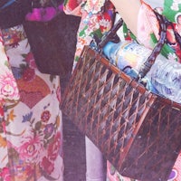 a woman in a kimono is holding a bag