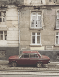 a red car parked in front of a building